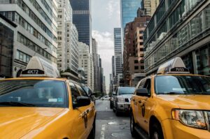 Two yellow cabs in a traffic jam in NYC.